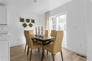 Dining area with light hardwood / wood-style flooring