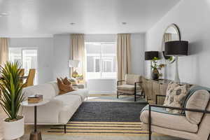 Living room with a healthy amount of sunlight, wood-type flooring, and a textured ceiling