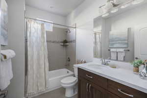 Full bathroom with tile patterned floors, vanity, toilet, and shower / bathtub combination with curtain