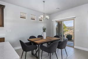 Tiled dining space featuring a chandelier