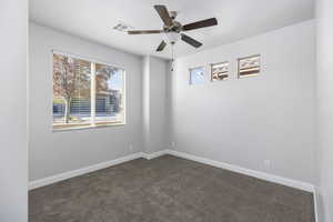 Carpeted empty room featuring ceiling fan