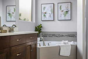 Bathroom with vanity and tiled tub