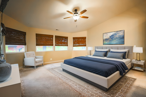 Bedroom with ceiling fan, lofted ceiling, and carpet floors