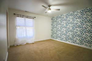 Spare room featuring ceiling fan and carpet