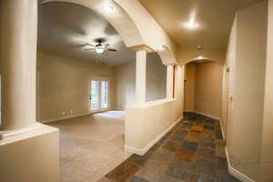 Hallway with decorative columns and dark carpet