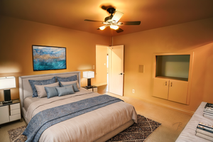 Bedroom with ceiling fan and light carpet