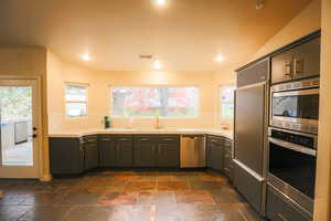 Kitchen featuring appliances with stainless steel finishes, backsplash, plenty of natural light, and sink