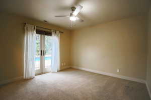 Carpeted spare room with ceiling fan