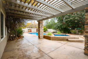 View of patio featuring a pool with hot tub and a pergola