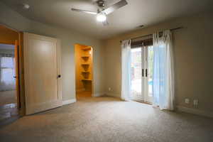 Unfurnished room featuring carpet, ceiling fan, and french doors