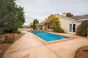 View of swimming pool with a patio area, a jacuzzi, and french doors