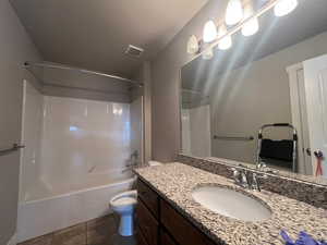 Full bathroom featuring tile patterned flooring, vanity, toilet, and shower / washtub combination