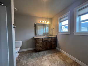 Bathroom featuring vanity, toilet, and a wealth of natural light