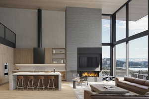 Living room with a fireplace, expansive windows, light hardwood / wood-style floors, and plenty of natural light