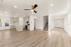 Unfurnished living room with light hardwood / wood-style flooring, ceiling fan, and sink