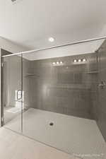 Bathroom with tile patterned flooring and a shower with shower door