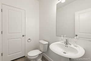 Bathroom with toilet, hardwood / wood-style floors, and sink