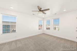 Carpeted spare room with ceiling fan