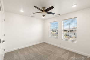 Carpeted empty room with ceiling fan