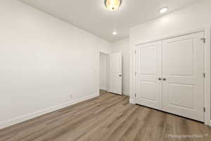 Unfurnished bedroom featuring light hardwood / wood-style floors and a closet