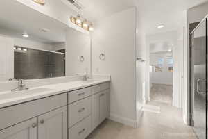 Bathroom with vanity, tile patterned floors, and walk in shower