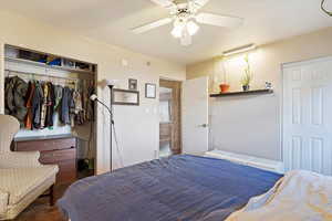 Bedroom with hardwood / wood-style floors, ceiling fan, and a closet