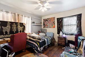 Bedroom with dark hardwood / wood-style floors and ceiling fan