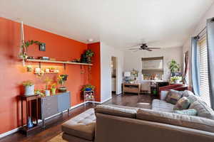 Living room with ceiling fan and dark hardwood / wood-style flooring