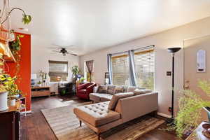 Living room featuring ceiling fan and dark hardwood / wood-style flooring