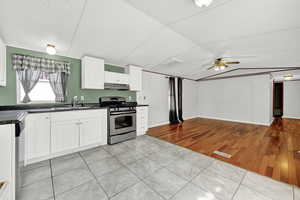 Kitchen featuring white cabinets, sink, ceiling fan, appliances with stainless steel finishes, and light hardwood / wood-style floors