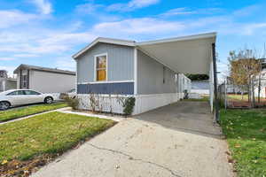 View of property exterior featuring a lawn and a carport