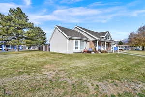 View of front of property with covered porch and a front lawn