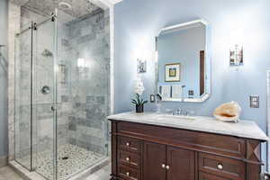 Bathroom featuring vanity and a shower with shower door