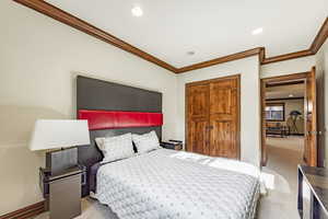 Bedroom featuring light carpet and ornamental molding