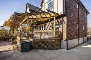 Rear view of house with a pergola, a wooden deck, and a patio area