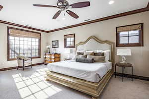 Bedroom featuring light carpet, ceiling fan, and crown molding