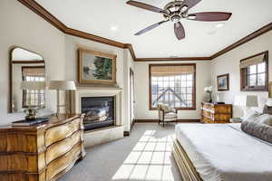 Carpeted bedroom with ceiling fan and ornamental molding