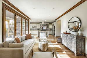 Living room with light hardwood / wood-style floors and ornamental molding