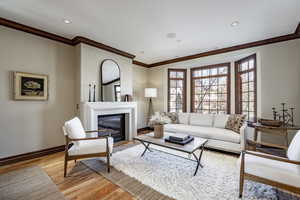 Living room featuring light wood-type flooring and crown molding