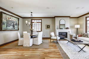 Dining area featuring light hardwood / wood-style flooring, ornamental molding, and a notable chandelier