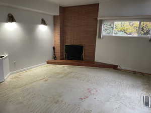 Unfurnished living room with vaulted ceiling and a tiled fireplace