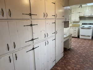 Kitchen with white range with electric stovetop and tasteful backsplash