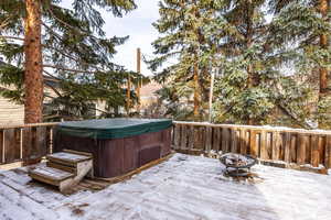 Wooden deck with a fire pit and a hot tub