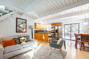 Living room featuring light hardwood / wood-style floors and beam ceiling