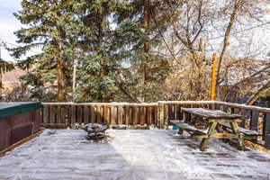 Snow covered deck featuring a fire pit and a hot tub