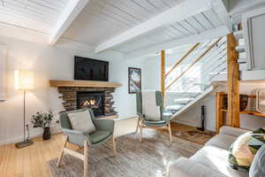 Living room with hardwood / wood-style floors, a fireplace, and beamed ceiling