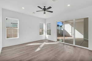 Unfurnished room with ceiling fan and hardwood / wood-style flooring