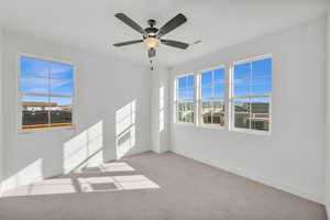 Carpeted empty room featuring ceiling fan