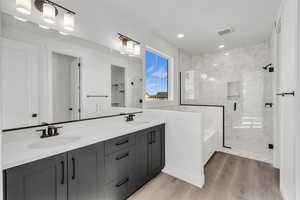 Bathroom featuring hardwood / wood-style floors, vanity, and independent shower and bath