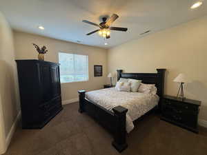 Bedroom with dark colored carpet and ceiling fan